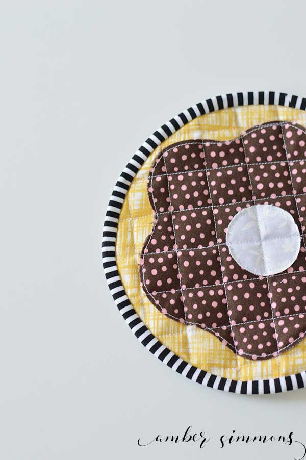 Could your kitchen use more donuts? Follow this tutorial to make a Frosted Donut Hot Pad. Use the Cricut Maker to cut out the pattern to make this adorable pastry pot holder. | ambersimmons.com 
